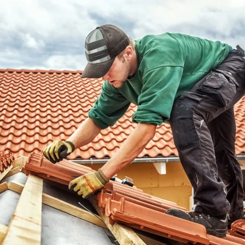 Roofer at work, installing clay roof tiles, Germany